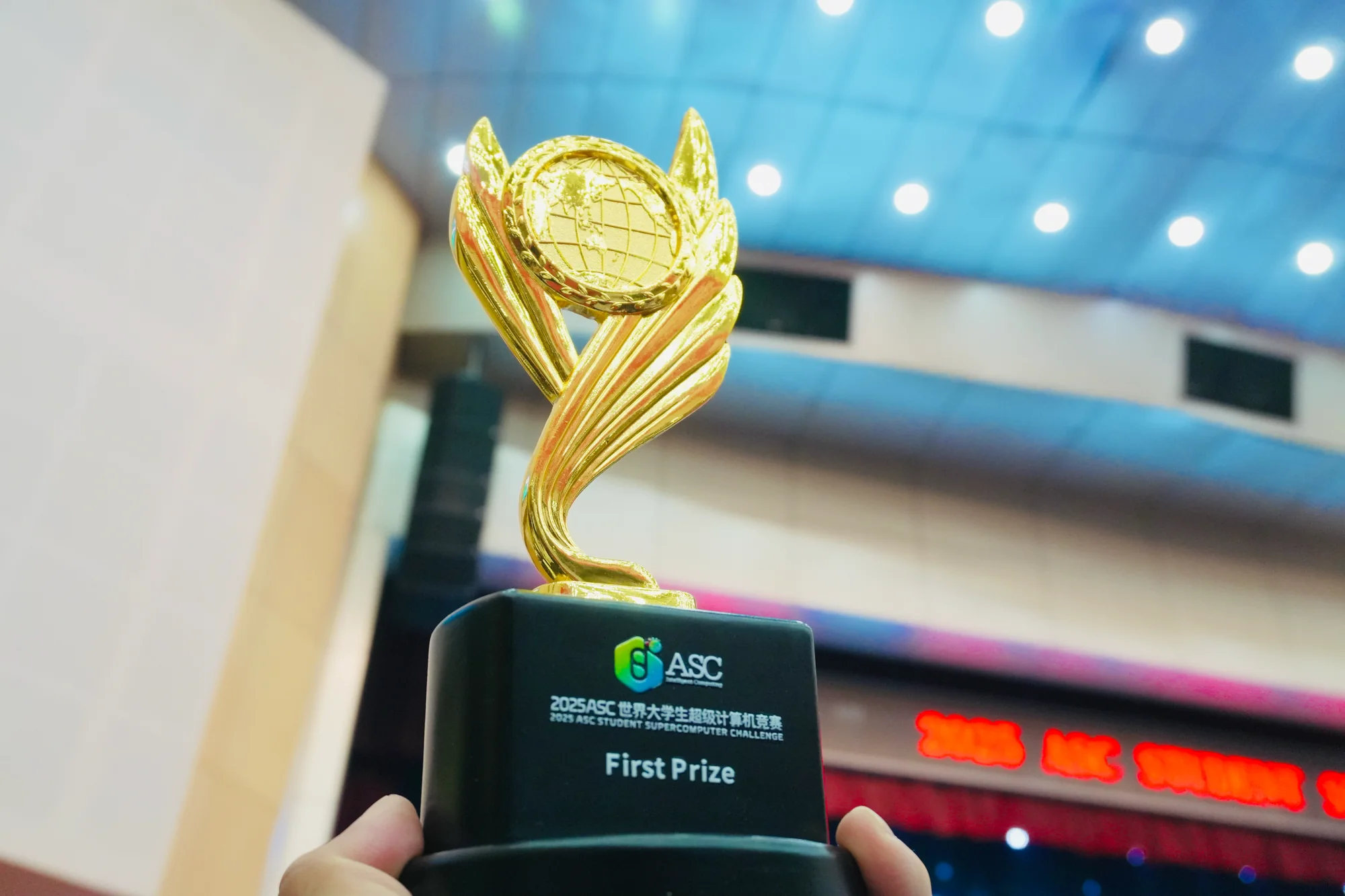 The gold 2025 ASC First Prize trophy, held up