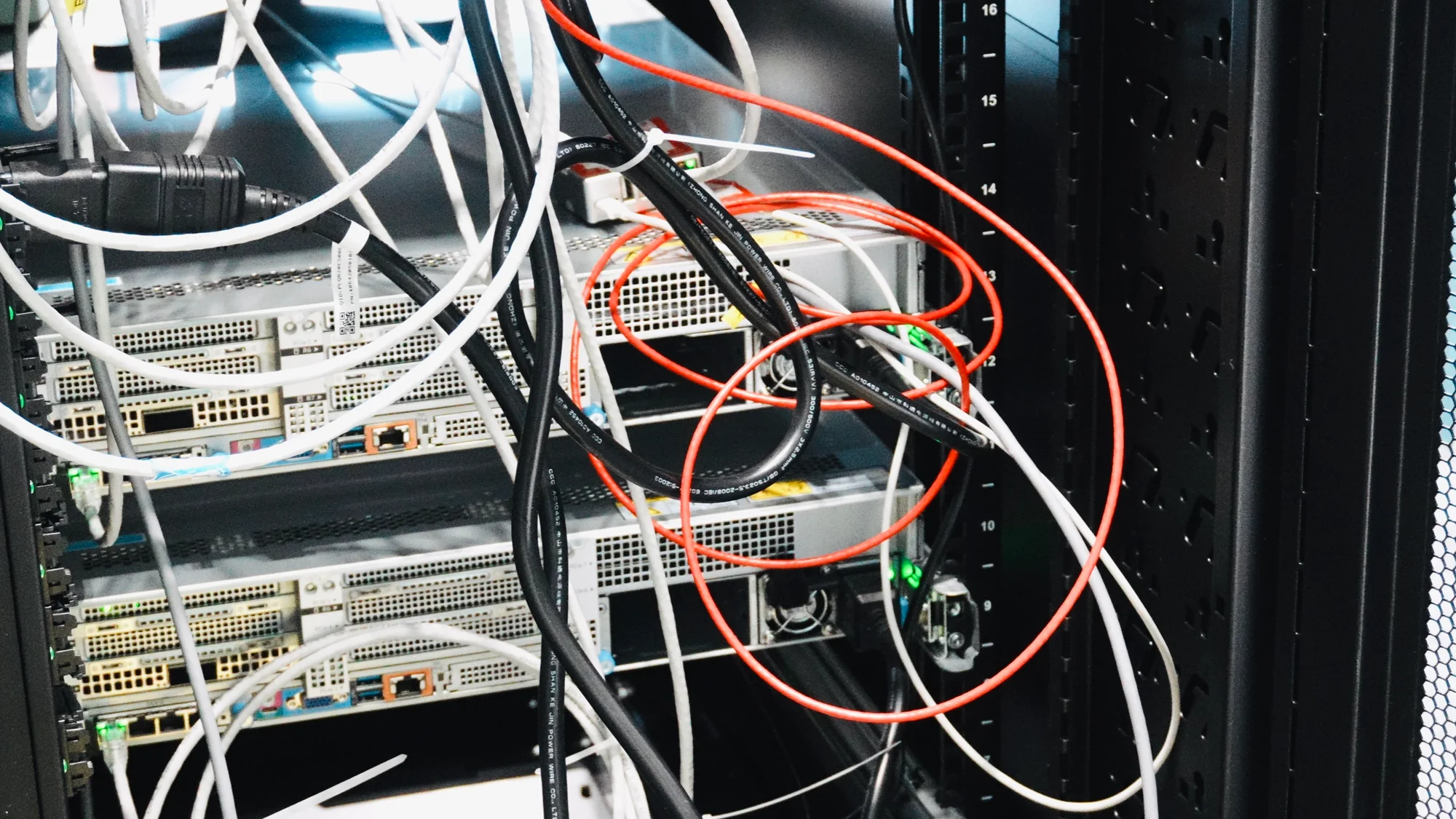 Servers in a rack, their backs tangled with power and network cables